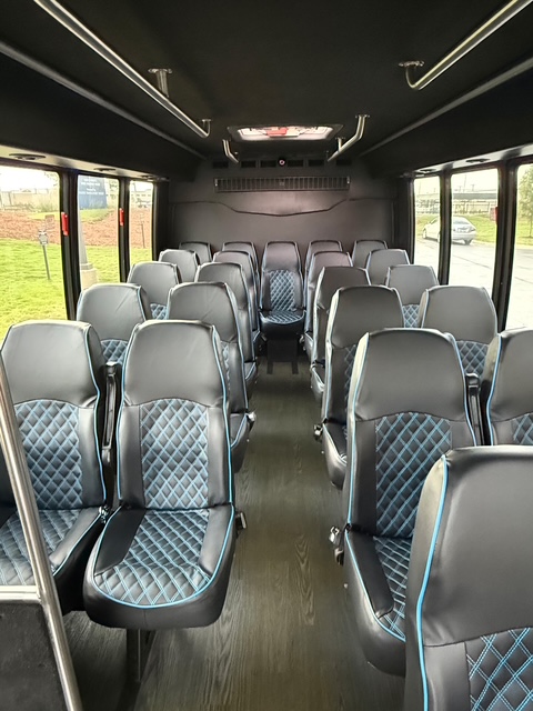 Shuttle bus interior with black and blue diamond-stitched leather seating